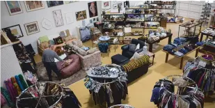  ?? OLIVIA HARLOW/THE NEW MEXICAN ?? Store Manager Ira Clark organizes items Tuesday to prepare for the Horse Shelter Resale Store’s ‘soft opening’ Friday.