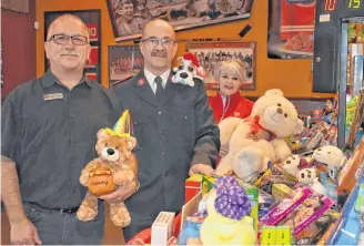  ??  ?? Kenny Burke (left) of Bridgewate­r’s Boston Pizza and Salvation Army volunteers Wilson (middle) and Darlene Sutton (right) pose with the donations from Kenny’s 10th annual toy drive.