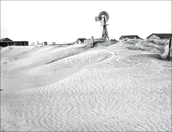  ?? AP, FILE ?? Desolation in this part of the Dust Bowl is graphicall­y illustrate­d by these rippling dunes banked against a fence, farm home, barn and windmill in Guymon, Okla., on March 29, 1937. This property was abandoned by its owner when destructiv­e dust clouds forced him to seek fortune elsewhere.