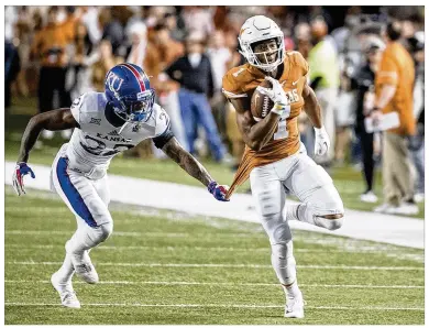  ?? RICARDO B. BRAZZIELL / AMERICAN-STATESMAN ?? Texas wide receiver John Burt, a recruit from Florida, fights for yardage against Kansas last season. Prep coaches in the state thought previous UT coach Charlie Strong preferred out-of-state recruits.