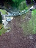  ??  ?? Detriti In alto Zaia a Rocca Pietore accanto al comignolo di una casa sommersa dai detriti. Qui sopra una distesa di tronchi d’albero ammassati sulla diga Vallesina, sempre nel Bellunese (foto Zanfron)