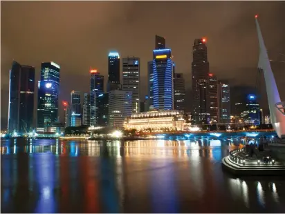  ?? (Sergi Reboredo/Sipa USA/TNS) ?? SINGAPORE'S SKYLINE financial district at dusk.