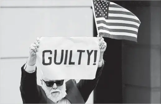  ?? WIN MCNAMEE GETTY IMAGES ?? A lone protester appeared at a courthouse hearing for the Paul Manafort case. Here the man holds up a sign and an American flag after the guilty verdict was announced.
