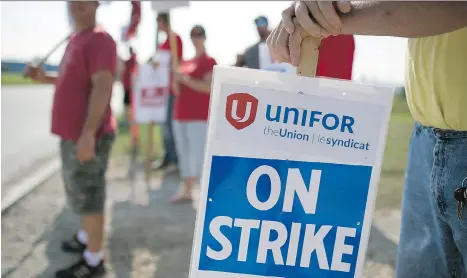  ?? JAMES MACDONALD/BLOOMBERG ?? Employees and Unifor members hold “On Strike” signs outside the General Motors Co. plant in Ingersoll, Ont., Wednesday in a dispute over job security. Job security remains the key sticking point between the company and Unifor Local 88.