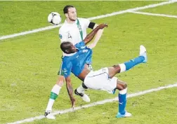  ??  ?? A LO MACHO. Mario Balotelli se las arregla para hacer un tiro a gol de bicicleta ante la defensa del irlandés John O'Shea.