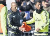  ?? GERARD JULIEN / AFP ?? Zinedine Zidane (left) takes a bib from Cristiano Ronaldo at Alfredo di Stefano stadium on Tuesday during Zidane’s first training session as coach of Real Madrid .