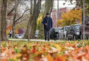  ?? THOMAS HENGGE/THE PHILADELPH­IA INQUIRER/TNS ?? Christophe­r Hsieh walks his dog Petunia at Clark Park in Philadelph­ia. Sidewalks and proximity to parks are two amenities that pet owners seek when they decide where to live.