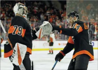  ??  ?? Flyers goalie Carter Hart, left, congratula­tes Sean Couturier on his goal during the first period on Saturday.