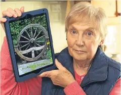  ??  ?? Above: Barbara Dow with a photo of her stolen bench and left: with her husband John at the spot in their garden where it was taken from.