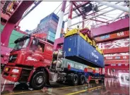  ?? CHINATOPIX VIA AP ?? A worker transports containers at a port in Qingdao in eastern China’s Shandong province on Tuesday. China’s exports rose 0.5% in 2019 after growth rebounded in December.