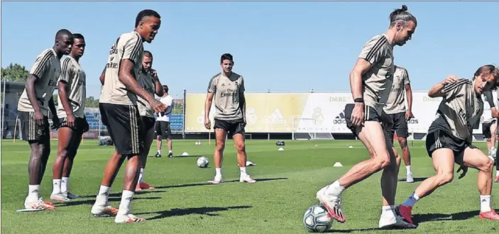  ??  ?? Los jugadores del Real Madrid, con Modric disputándo­le el balón a Bale, en un rondo durante el último entrenamie­nto de la plantilla, ayer en Valdebebas.