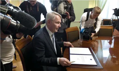  ?? ?? Finland’s foreign minister, Pekka Haavisto, signs the country’s petition for Nato membership. Photograph: Antti Aimo-Koivisto/Rex/ Shuttersto­ck