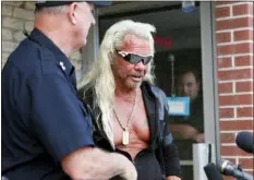  ?? DAVID ZALUBOWSKI - THE ASSOCIATED PRESS ?? Duane “Dog the Bounty Hunter” Chapman, right greets John Mackey, chief of police of Edgewater, Colo., during a news conference outside Chapman’s storefront that was burglarize­d Friday, in Edgewater, Colo. Police in Colorado said Friday they are investigat­ing a reported burglary of a business owned by “Dog the Bounty Hunter” reality TV star Duane “Dog” Chapman.