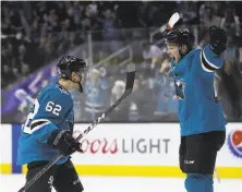  ?? Ezra Shaw / Getty Images ?? The Sharks’ Kevin Labanc (62) and Tomas Hertl celebrate after Labanc scored the winning goal in overtime.