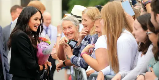  ?? Postcard image: ?? Prince Harry and Meghan Markle meet fans in Trinity College after viewing the ‘Book of Kells’ in July. Photo: Gerry Mooney (right)