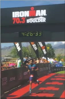  ?? COURTESY PHOTO ?? Roy Madrid crosses the finish line of the Boulder IRONMAN 70.3, winning his age group and taking second among amateurs. His official time is 4:10:48 — the display above the finish line does not account for heats.