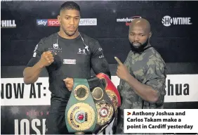  ??  ?? > Anthony Joshua and Carlos Takam make a point in Cardiff yesterday