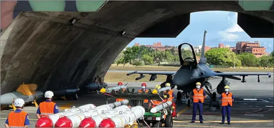  ?? AP FILE ?? DISPLEASED: Military personnel stand next to U.S. Harpoon A-84, anti-ship missiles and AIM-120 and AIM-9 air-to-air missiles prepared for a weapon loading drills in front of a U.S. F-16V fighter jet at the Hualien Airbase in Taiwan’s southeaste­rn Hualien county.