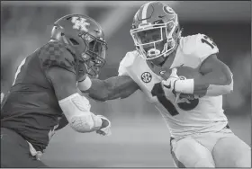  ?? AP Photo/Bryan Woolston ?? Georgia running back Elijah Holyfield (13) stiff arms Kentucky safety Mike Edwards (7) during the second half of Saturday’s college football game in Lexington, Ky.