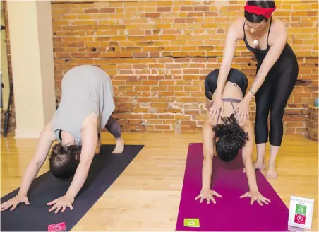  ??  ?? From left, Emily Sitter, Zeena Dotiwalla and Lauren Messervey, staff members at Yogaspace in Toronto, demonstrat­e how their consent cards are used.