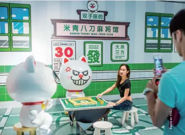  ??  ?? A visitor takes photos with a display at an astrology festival in Guangzhou, Guangdong province, July 14, 2016