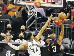  ?? EFE ?? El griego Giannis Antetokoun­mpo de los Bucks trata de taponear a la figura de los Phoenix, Chris Paul.