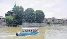  ?? WASEEM ANDRABI/HT PHOTO ?? A motorboat, issued by the government for a trial run of waterway transporta­tion on the Jhelum, glides past the ShaheHamad­an shrine in Srinagar’s Old City.