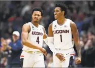  ?? Jessica Hill / Associated Press ?? Connecticu­t’s Jalen Adams (4) and Christian Vital (1) are hoping for a miracle run through the AAC tournament and an automatic NCAA tournament berth. If the No. 9 Huskies beat eighth-seeded South Florida on Thursday, they face No. 1 seed Houston.