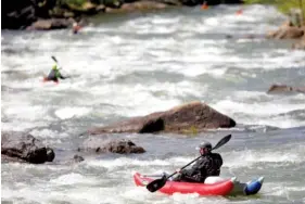  ?? STAFF FILE PHOTO BY C.B. SCHMELTER ?? Ryan Henkel, bottom, and others boat on the Middle Ocoee River on Saturday, April 25, 2020, in Polk County, Tenn. A recent study shows Tennessee had a disproport­ionate share of paddling deaths in 2020. Tennessee was tied with Arkansas.