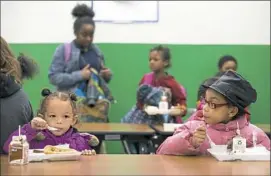  ?? Antonella Crescimben­i/Post-Gazette ?? Jamaya Glover, 3, left, and Camara Bench, 8, right, eat their dinners on Tuesday at Kelly Elementary School in Wilkinsbur­g. The Wilkinsbur­g School District, in partnershi­p with The Nutrition Group, launched a free after-school dinner program for all...