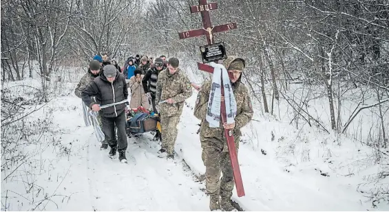  ?? ?? Bajas. El entierro de un militar ucraniano del batallón Azov, que murió defendiend­o la ciudad de Bakhmut, en la región del Donbáss.AFP