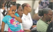  ?? Arkansas Democrat-Gazette/THOMAS METTHE ?? Tiffany Swiney holds her sister, Khalea, 3, as they listen Saturday to Little Rock Nine members Elizabeth Eckford and Thelma Mothershed Wair speak in the Old Supreme Court Room at the Capitol in Little Rock.