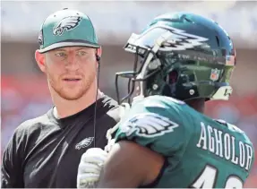  ?? KIM KLEMENT/USA TODAY SPORTS ?? Eagles quarterbac­k Carson Wentz, talking Sunday with wide receiver Nelson Agholor, will be back in uniform this coming Sunday.