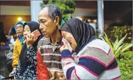  ?? Ulet Ifansasti Getty Images ?? A WOMAN who gave her name as Ida waits for news in Jakarta about the crash. She said her daughter, son-in-law and two grandchild­ren were on the plane.