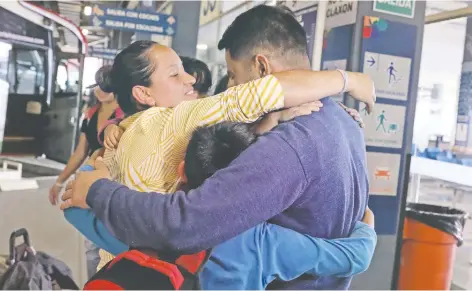  ??  ?? La migrante venezolana Yance Plaza abraza a su esposo David Pernia y a su hijo, al llegar a la terminal de autobuses de Lima, la capital peruana.