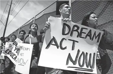  ?? PAT SHANNAHAN/THE REPUBLIC ?? Jose Patino, then an ASU student, wears a graduation cap and gown in 2010 while marching in support of the DREAM Act.