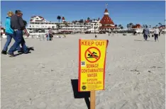  ??  ?? CORONADO: A sign warns of sewage contaminat­ed ocean waters on a beach in front of the iconic Hotel del Coronado in Coronado, Calif. For more than two weeks last month, a stench of feces, ammonium and laundry detergent wafted through the air along...