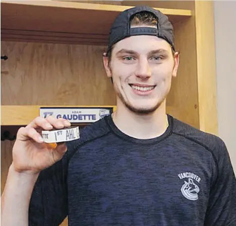  ??  ?? Adam Gaudette shows off the puck after netting his first profession­al goal on Friday for the Utica Comets in a 4-3 loss to the Charlotte Checkers. After two goals and two assists in four games with the AHL squad, Gaudette will lace up with the Canucks tonight in place of Jay Beagle, who broke his hand.