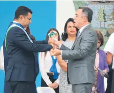  ??  ?? CEREMONIA. El alcalde Morales toma el bastón de mando de manos del gobernador René Castellano­s.