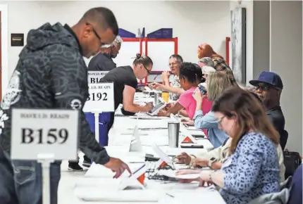  ?? MATT STONE/COURIER JOURNAL ?? ABOVE: People check in to vote inside the Evangel World Prayer Center that was a voting hub for a few precincts. One election worker said voting has been busier since the primary.