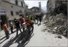  ?? ALESSANDRA TARANTINO — THE ASSOCIATED PRESS ?? The body of a victim is pulled out of the rubble earthquake in Amatrice Italy, Wednesday. following an