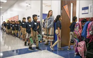  ?? JAY JANNER / AMERICAN-STATESMAN ?? Third-grade reading teacher Allison Morgan helps KIPP Austin Obras Elementary School students change classrooms on the first day of school Monday.