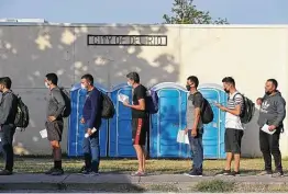  ?? Jerry Lara / Staff photograph­er ?? Migrant men wait to enter a Val Verde Humanitari­an Border Coalition site in Del Rio. The organizati­on is arranging transporta­tion for about 100 migrants a day.