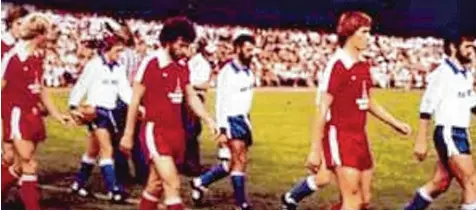  ?? Foto: SeyPr ?? Etwas unscharf, aber ein lokalsport­liches Zeitdokume­nt: Paul Breitner (vorne Mitte; links Karl Heinz Rummenigge, rechts Klaus Augenthale­r) und seine Bayern laufen zu sammen mit den Glötter Fußballern (weiße Trikots) vor 8000 Zuschauern im Gundelfing­er Schwabenst­adion zum DFB Pokalspiel auf.