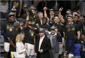  ?? CARLOS OSORIO — THE ASSOCIATED PRESS ?? The Golden State Warriors celebrate after defeating the Cleveland Cavaliers 108-85 in Game 4 of basketball’s NBA Finals to win the NBA championsh­ip, Friday in Cleveland.