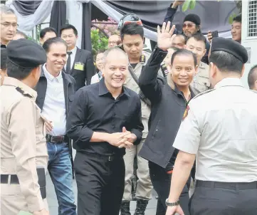  ??  ?? Red shirt leader Nattawut Saikua (centre) and other leaders wave to the media as they leave the Military court in Bangkok.— Reuters photo