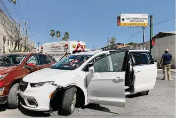  ?? STR/Associated Press ?? A member of the Mexican security forces stands next to a white minivan with North Carolina plates and several bullet holes, at the crime scene where gunmen kidnapped four U.S. citizens who crossed into Mexico from Texas, on March 3.