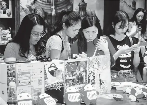  ?? PROVIDED TO CHINA DAILY ?? Women try out mobile phone games at an exhibition in Shanghai in July last year.