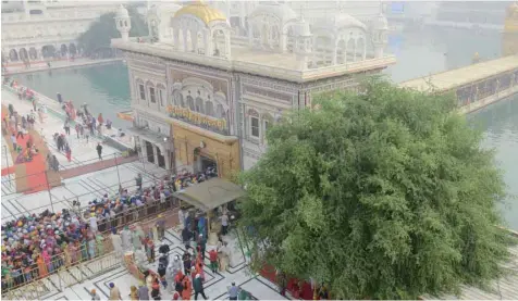  ?? — AFP ?? Sikh devotees pay their respects during an event to mark 548th birth anniversar­y of Sri Guru Nanak Dev at the Golden Temple in Amritsar on Saturday.