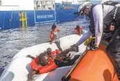  ?? ANNA PANTELIA MSF VIA AP ?? A Doctors Without Borders team rescues migrants Monday from a rubber boat in distress off Libya’s coast.